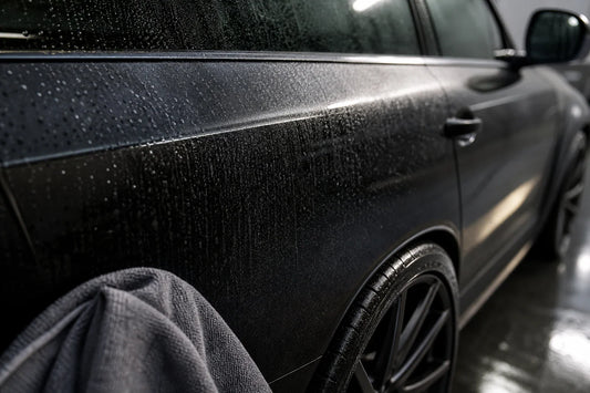 Premium close-up of clean car panel and wheel after water spot care